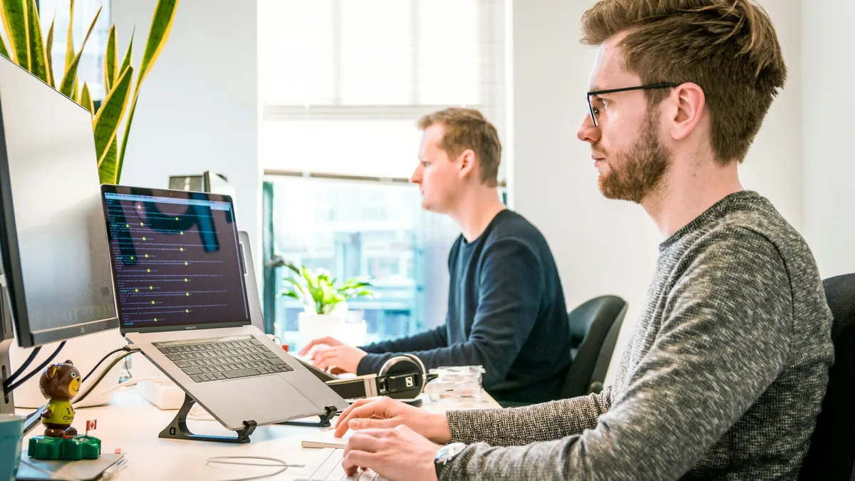 Technology team reviewing bulk B2B prospect lists, domain match scores, and CRM data enrichment on multiple screens