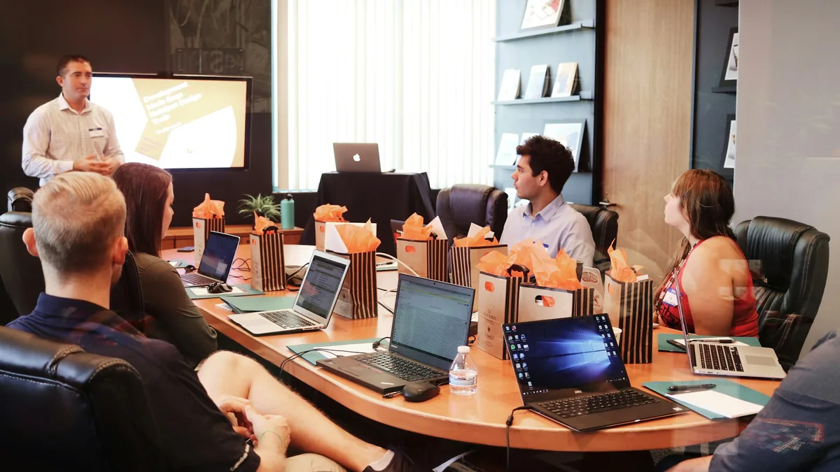 Business founders reviewing scenario planning and sensitivity forecasts on a boardroom whiteboard