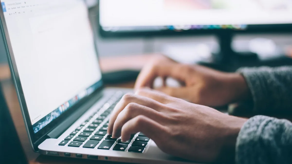 Content writer editing article text on laptop to optimize keyword frequency and avoid keyword stuffing