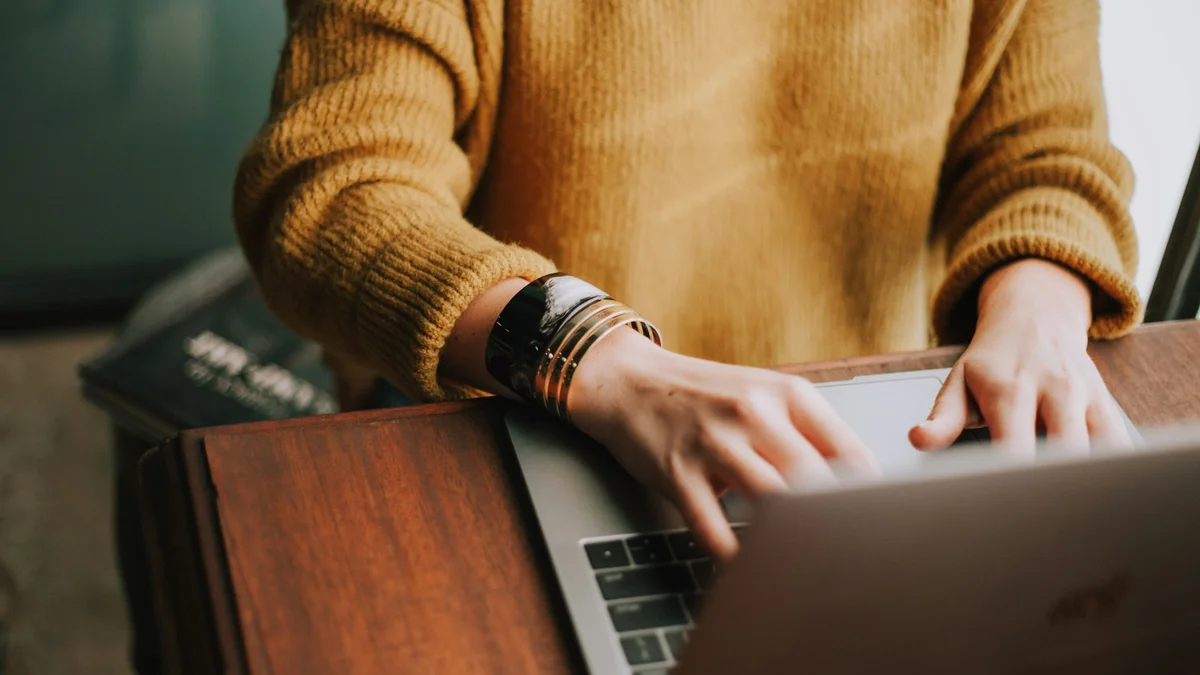 Author drafting and publishing content on laptop for online article submission